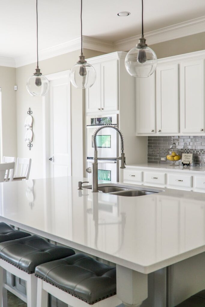 Spacious modern kitchen with white cabinets and island in natural light.