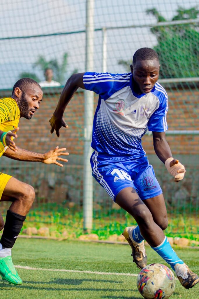 Two male soccer players engage in an intense match on an outdoor field.