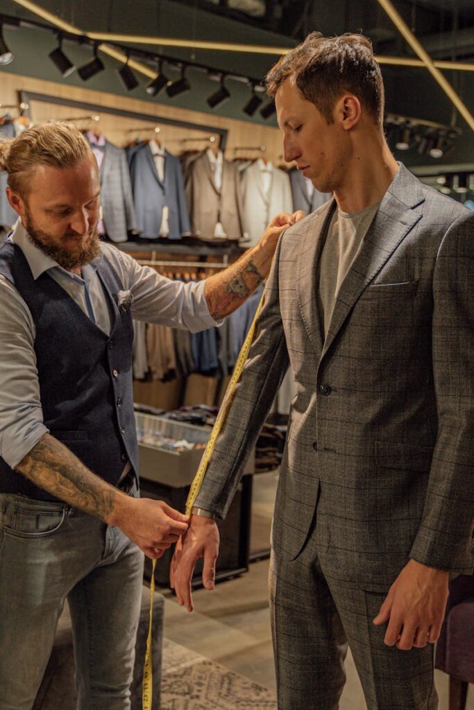 Tailor measuring a customer in a suit store for a perfect fit.